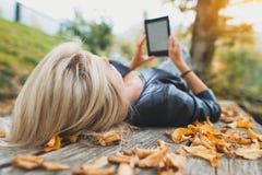 Blonde girl reads a book from her ebooks readers stock image Blonde girl reads a book from her ebooks readers stock image