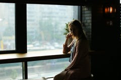 Blonde girl sitting near window at cafe. royalty free stock image Blonde girl sitting near window at cafe. royalty free stock image