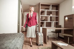 Blonde-haired woman coming to hotel room with her luggage royalty free stock images Blonde-haired woman coming to hotel room with her luggage royalty free stock images