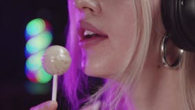 Blonde sexy gamer girl sucking a lollipop