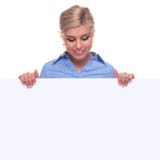 Blonde vrouw die een lege berichtraad houdt. stock afbeeldingen Blonde vrouw die een lege berichtraad houdt. stock afbeeldingen