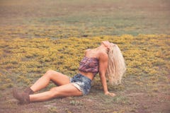 Blonde woman in shorts and boots in field