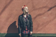 Blondynki dziewczyna w czerwonym włosianym bandażu i czarnej skórzanej kurtce obrazy stock Blondynki dziewczyna w czerwonym włosianym bandażu i czarnej skórzanej kurtce obrazy stock