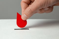 Blood Donor. Man Puts Drop Of Blood In The Piggy Bank As Donation. Concept Donate Blood Save Life Royalty Free Stock Photos Blood Donor. Man Puts Drop Of Blood In The Piggy Bank As Donation. Concept Donate Blood Save Life Royalty Free Stock Photos