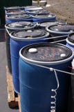 Blue plastic 55 gallon drums full of various flammable waste at a recycling plant