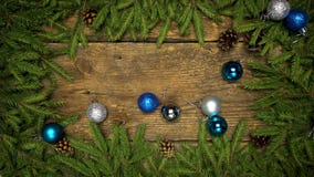 Christmas decorations falling on a wooden background with fir branches and cones ready for your design. Winter holidays