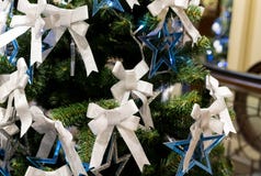 Blue star many white bow Christmas decorations on festive fluffy branches stock images Blue star many white bow Christmas decorations on festive fluffy branches stock images