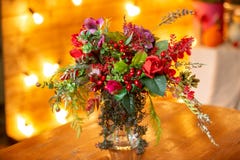 Blumenanordnung mit roten Beeren, roten Rosen und Grüns auf dem Tisch lizenzfreie stockfotos Blumenanordnung mit roten Beeren, roten Rosen und Grüns auf dem Tisch lizenzfreie stockfotos