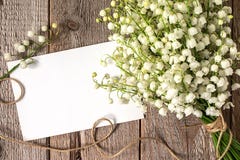 Blumenstrauß des Blumenmaiglöckchens und des leeren Papierblattes Lizenzfreies Stockbild Blumenstrauß des Blumenmaiglöckchens und des leeren Papierblattes Lizenzfreies Stockbild