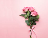 Blumenstrauß von frischen Rosen mit einem rosa Band auf einem rosa Hintergrund Ansicht von oben stockbild Blumenstrauß von frischen Rosen mit einem rosa Band auf einem rosa Hintergrund Ansicht von oben stockbild