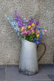 Blumenstrauß von mehrfarbigen Wildflowers in einem alten Metallkrug stockfotografie Blumenstrauß von mehrfarbigen Wildflowers in einem alten Metallkrug stockfotografie