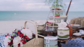 Blur on video. Picnic on the beach. Food and beverages are placed on the table, there is a place to sit and an umbrella to protect