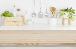 Blurred kitchen workplace with empty wooden table top in front