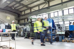 Blurred motion of business people wearing reflective clothing walking in metal industry stock images Blurred motion of business people wearing reflective clothing walking in metal industry stock images