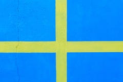 Blå vägg med målade gula band som är liknande till den svenska flaggan Bakgrund arkivfoton Blå vägg med målade gula band som är liknande till den svenska flaggan Bakgrund arkivfoton