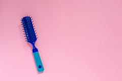 Blått plast- hår för att kamma hår på rosa bakgrund med copyspace royaltyfria foton Blått plast- hår för att kamma hår på rosa bakgrund med copyspace royaltyfria foton