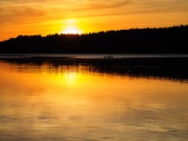 Boat sailing in the distance at sunset. Silhouette of a boat on the river royalty free stock photography Boat sailing in the distance at sunset. Silhouette of a boat on the river royalty free stock photography