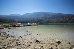 Boats on the blue lake of Kournas in the background of the mountains in Crete royalty free stock image Boats on the blue lake of Kournas in the background of the mountains in Crete royalty free stock image