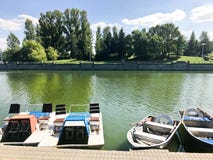 Boats and catamarans on a pond lake in a river canal with green flowered water are moored on the shore stock photo Boats and catamarans on a pond lake in a river canal with green flowered water are moored on the shore stock photo