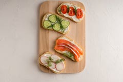 Bocadillos frescos con los salmones, el pepino, los tomates, los aguacates y los verdes fotos de archivo libres de regalías Bocadillos frescos con los salmones, el pepino, los tomates, los aguacates y los verdes fotos de archivo libres de regalías
