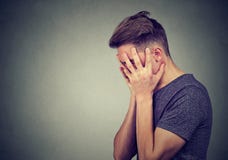 Boczny profil smutny młody człowiek patrzeje w dół z rękami na twarzy Depresji i niepokoju nieład zdjęcia stock Boczny profil smutny młody człowiek patrzeje w dół z rękami na twarzy Depresji i niepokoju nieład zdjęcia stock