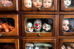 Body parts and faces of crying kids and smiley actors. Dolls inside wooden house for play. Broken toys for game stock image Body parts and faces of crying kids and smiley actors. Dolls inside wooden house for play. Broken toys for game stock image