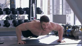 Bodybuilding den muskulösa idrottsman nen med den härliga sportkroppen gör liggande armhävningar under maktgenomkörare på sportmi lager videofilmer Bodybuilding den muskulösa idrottsman nen med den härliga sportkroppen gör liggande armhävningar under maktgenomkörare på sportmi lager videofilmer