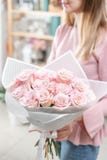 Boeket van rozen in de handen van vrouwen Bleke bos - roze het concept een bloemist in een bloemwinkel behang royalty-vrije stock fotografie Boeket van rozen in de handen van vrouwen Bleke bos - roze het concept een bloemist in een bloemwinkel behang royalty-vrije stock fotografie