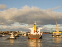 Bogserbåt som hjälper lastfartyget i stora partier för att lämna port royaltyfria bilder Bogserbåt som hjälper lastfartyget i stora partier för att lämna port royaltyfria bilder