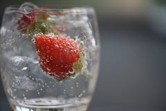 Boisson saine de l'eau de scintillement dans un verre avec les fraises et les bulles fraîches images libres de droits Boisson saine de l'eau de scintillement dans un verre avec les fraises et les bulles fraîches images libres de droits