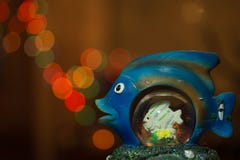 Bokeh da noite Peixes azuis da estatueta com círculos de incandescência coloridos do bokeh na noite fotografia de stock Bokeh da noite Peixes azuis da estatueta com círculos de incandescência coloridos do bokeh na noite fotografia de stock