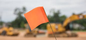 Bokeh shot of a warning flag in front of a row of heavy construction equipment. royalty free stock photo Bokeh shot of a warning flag in front of a row of heavy construction equipment. royalty free stock photo