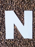 bokstav N i vit och bakgrund med grillade kaffebönor, bakgrund och textur arkivbild bokstav N i vit och bakgrund med grillade kaffebönor, bakgrund och textur arkivbild