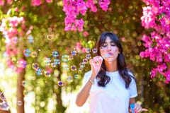 Bolhas de sab?o de sopro da jovem mulher bonita feliz exteriores imagem de stock Bolhas de sab?o de sopro da jovem mulher bonita feliz exteriores imagem de stock
