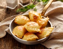 Bolinhas de massa cozidas enchidas com queijo e batatas de coalho em uma bandeja Fotografia de Stock Bolinhas de massa cozidas enchidas com queijo e batatas de coalho em uma bandeja Fotografia de Stock