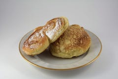 Bollos en azúcar en polvo en un plato blanco en un fondo blanco fotos de archivo Bollos en azúcar en polvo en un plato blanco en un fondo blanco fotos de archivo