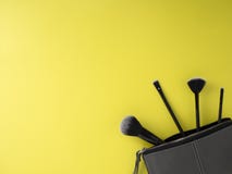 Bolso con los cepillos del maquillaje, cosméticos, fondo amarillo foto de archivo libre de regalías Bolso con los cepillos del maquillaje, cosméticos, fondo amarillo foto de archivo libre de regalías