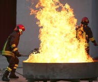 Bomberos durante un ejercicio de formación de un fuego en el brazie fotografía de archivo Bomberos durante un ejercicio de formación de un fuego en el brazie fotografía de archivo