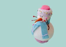 Bonhomme de neige d'isolement de jouet dans un chapeau rose et une écharpe bleue photo libre de droits Bonhomme de neige d'isolement de jouet dans un chapeau rose et une écharpe bleue photo libre de droits