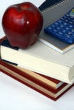 Books, calculator and apple