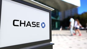 Bordo del contrassegno della via con il logo di JPMorgan Chase Bank Centro vago dell'ufficio e fondo di camminata della gente 3D illustrazione vettoriale Bordo del contrassegno della via con il logo di JPMorgan Chase Bank Centro vago dell'ufficio e fondo di camminata della gente 3D illustrazione vettoriale