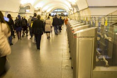 borrão Uma multidão de passagens dos povos com pressa através dos torniquetes eletrônicos na estação de metro em St Petersburg, R foto de stock borrão Uma multidão de passagens dos povos com pressa através dos torniquetes eletrônicos na estação de metro em St Petersburg, R foto de stock