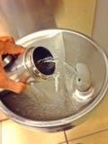 Botella de agua de relleno en el dispensador de la bebida foto de archivo libre de regalías Botella de agua de relleno en el dispensador de la bebida foto de archivo libre de regalías