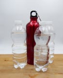 Botellas plásticas transparentes siguientes de la botella de agua roja tres Concepto de la reutilizaci?n imagenes de archivo Botellas plásticas transparentes siguientes de la botella de agua roja tres Concepto de la reutilizaci?n imagenes de archivo