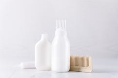 Bottiglie di plastica bianche con i prodotti per capelli, pettine di legno Concetto dei trattamenti dei capelli fotografie stock Bottiglie di plastica bianche con i prodotti per capelli, pettine di legno Concetto dei trattamenti dei capelli fotografie stock