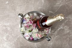 Bottle Of Champagne With Floral Ice Cubes In Bucket On Table Stock Photography