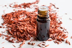 A bottle of sandalwood essential oil with sandalwood on white ba stock photos A bottle of sandalwood essential oil with sandalwood on white ba stock photos