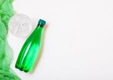 Bottle of sparkling mineral water with glass of ice and green cloth on white Stock Image Bottle of sparkling mineral water with glass of ice and green cloth on white Stock Image