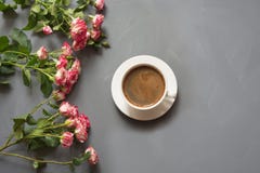 Bouquet des roses de buisson et de la tasse de café roses sur le fond gris chic minable, point de vue supérieure Photographie stock libre de droits Bouquet des roses de buisson et de la tasse de café roses sur le fond gris chic minable, point de vue supérieure Photographie stock libre de droits