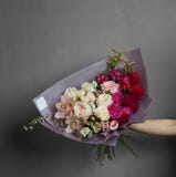 Bouquet frais sensible des fleurs dans la main tendue photo stock Bouquet frais sensible des fleurs dans la main tendue photo stock